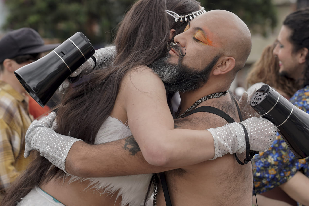 Abrazo entre personas en marcha LGBTI
