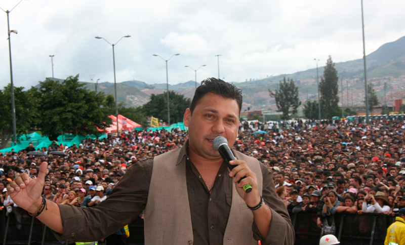 Cantante con un micrófono en la mano y espectadores de fondo