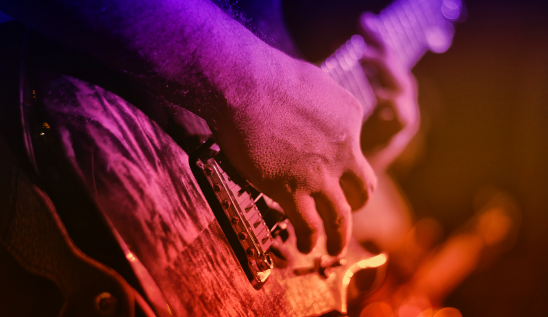 Primer plano de un hombre tocando una guitarra eléctrica