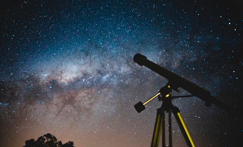 Imagen de un telescopio y estrellas de fondo