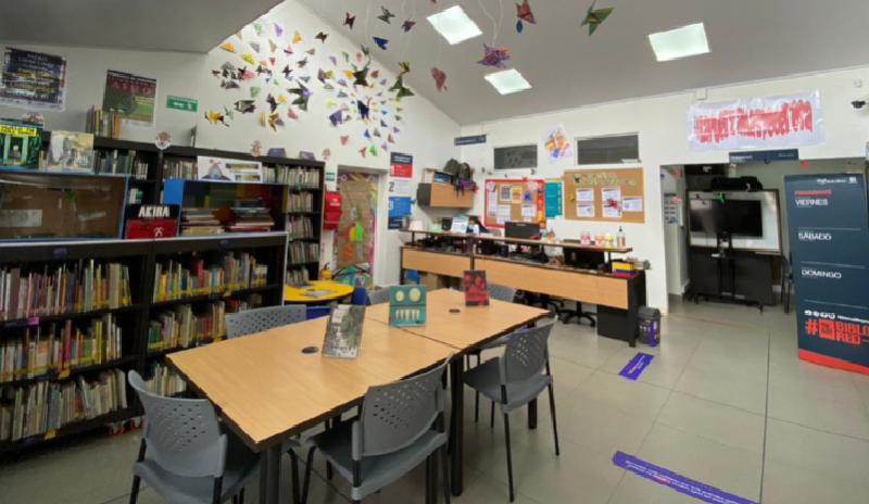 Fotografía interior de una de Biblioteca. Cuenta en el centro con una mesa de lectura y alrededor con estanterías de libros. 