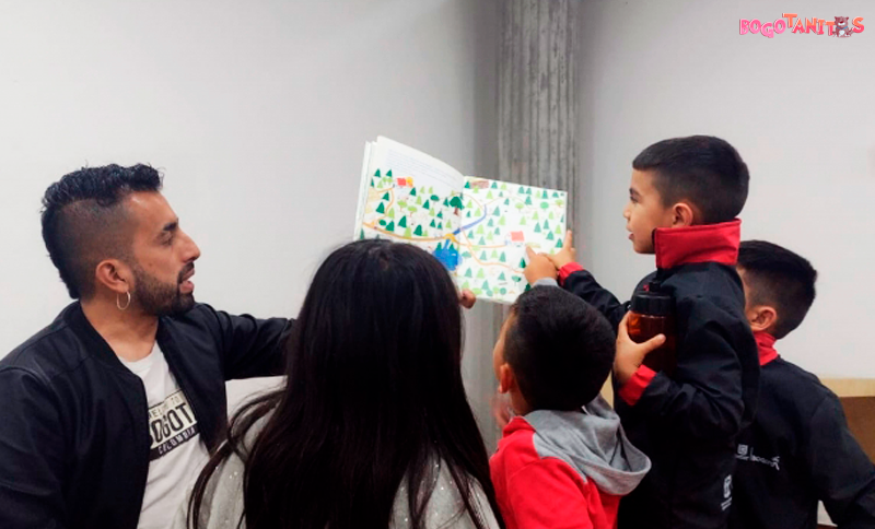 Adultos leyendo un libro a niños y niñas