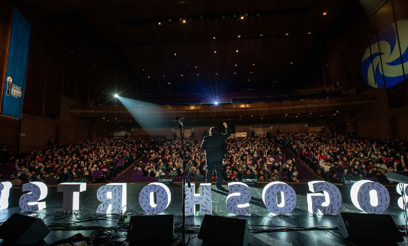 auditorio con personas y un presentador 