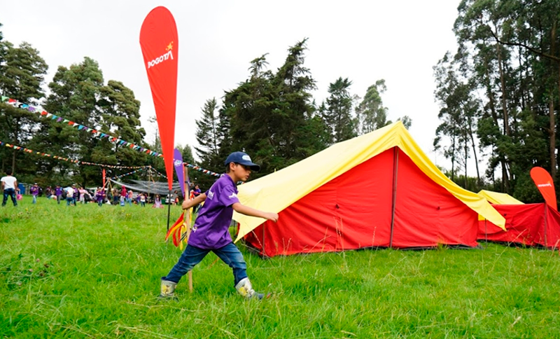 Niño caminando al lado de una carpa
