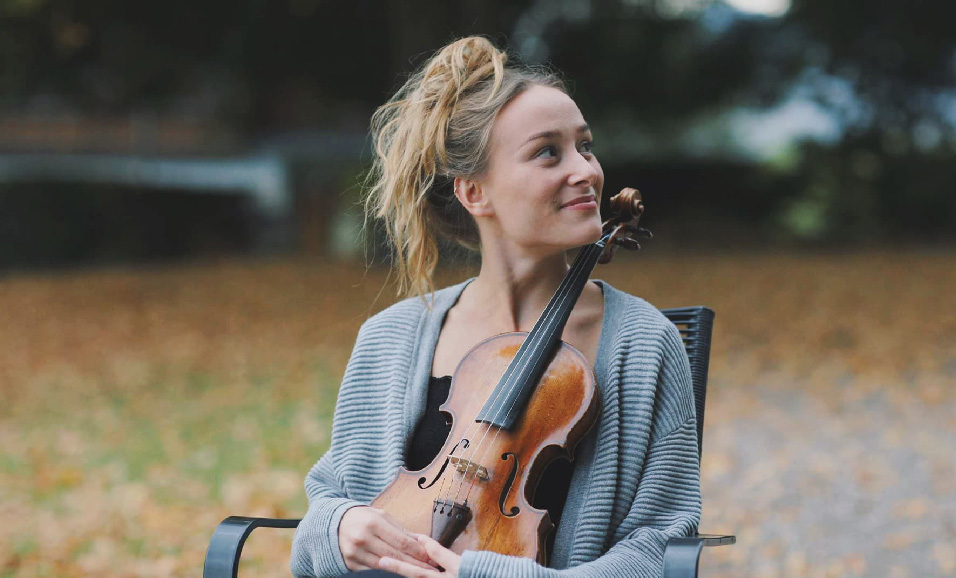 mujer sentada abrazando un violín