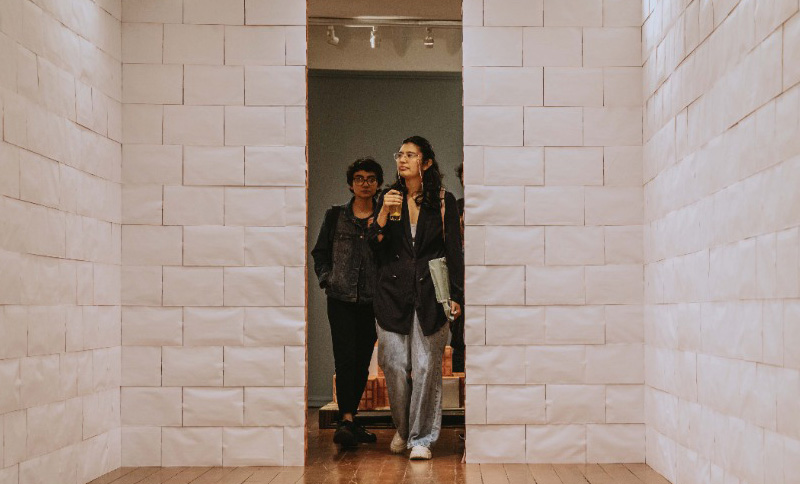 dos personas caminando por una exposición de arte