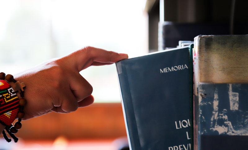 mano de una persona sacando un libro de un estante
