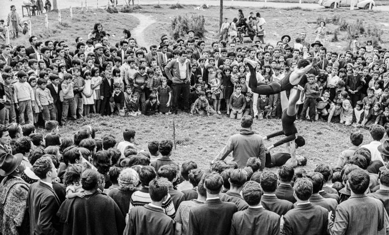 Foto de grupo de gente viendo artistas danzar