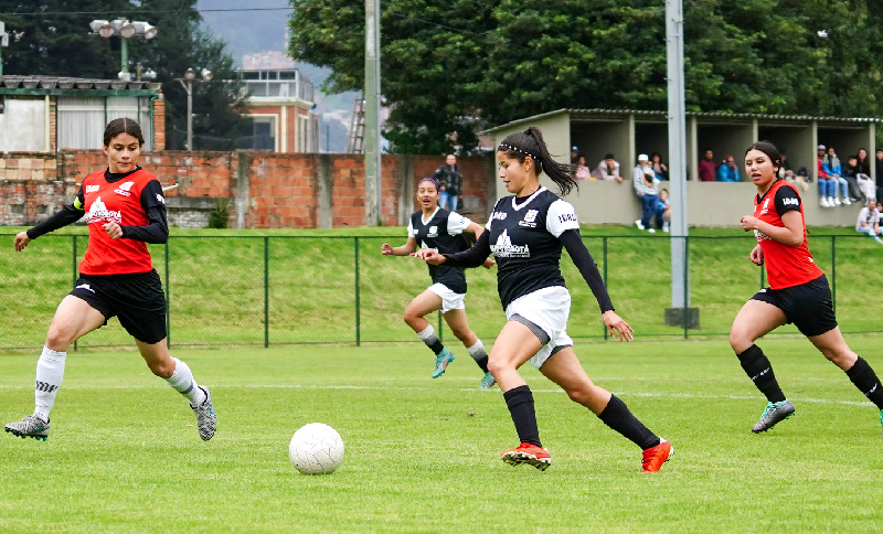 Mujeres jugando fútbol en una cancha
