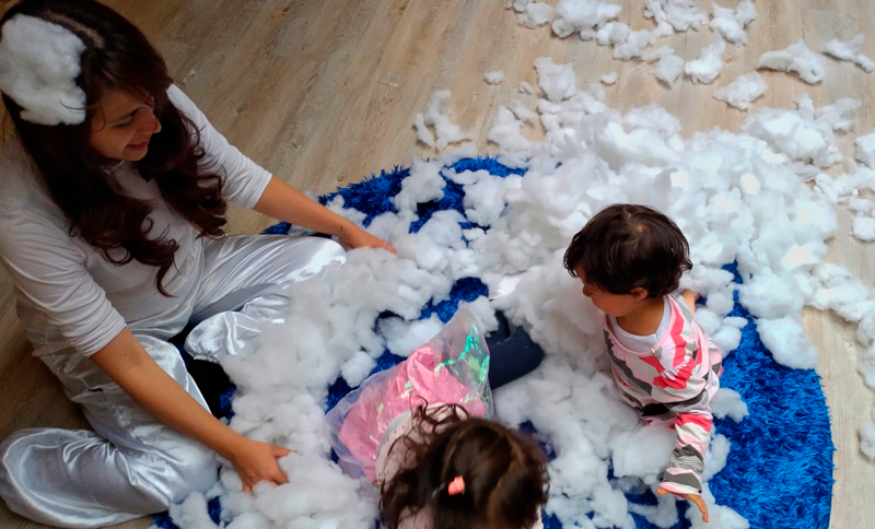 Mujer jugando con dos niños de primera infancia