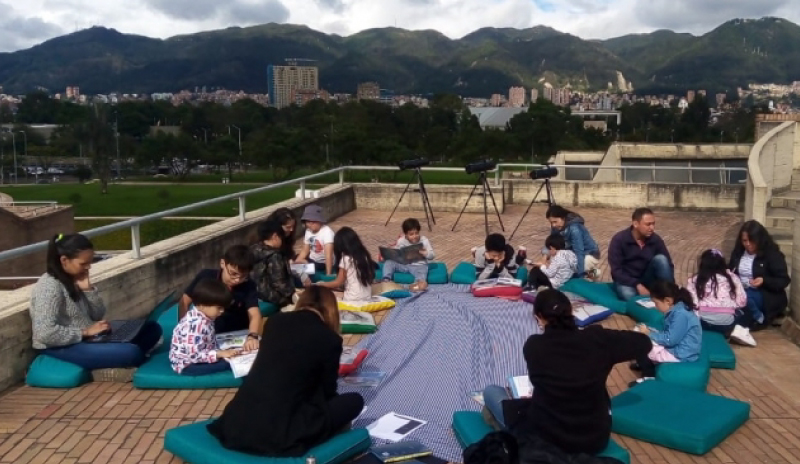Niños y niñas leyendo al aire libre