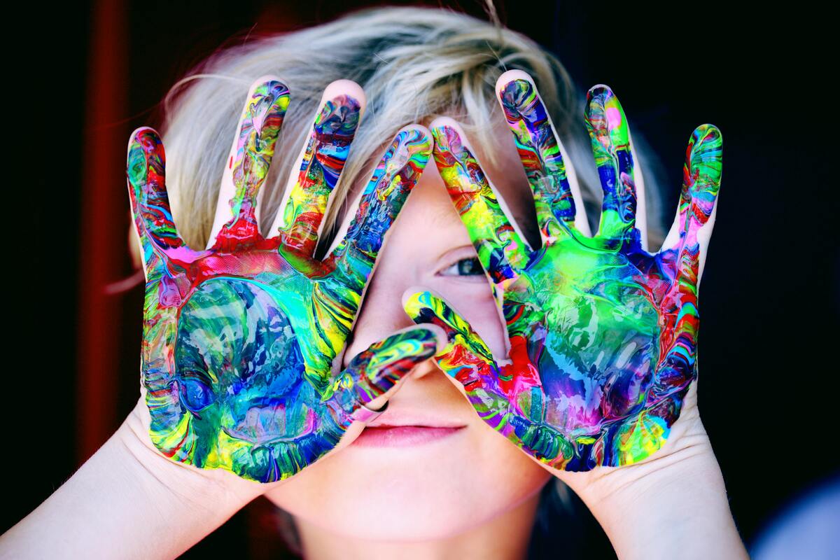 Niño con manos pintadas