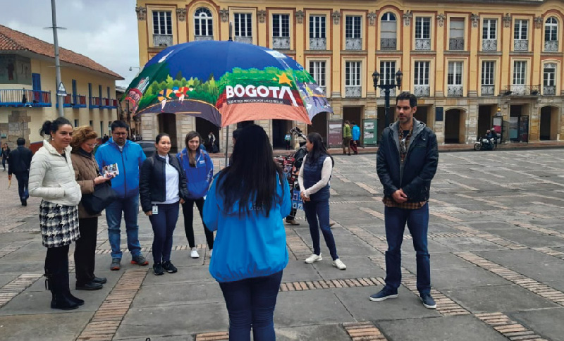 personas en la Plaza de Bolívar escuchando a una guía