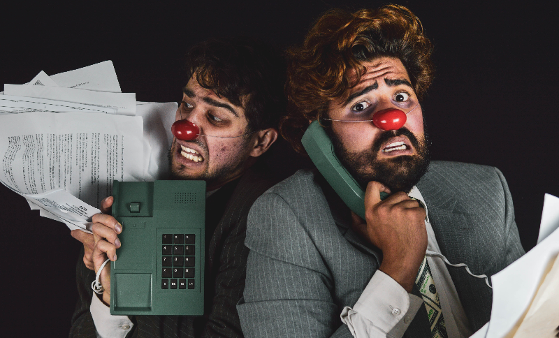 Artistas clown con teléfono antiguo en la mano
