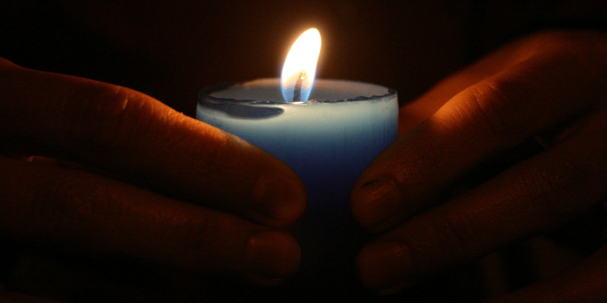 manos sosteniendo una vela encendida