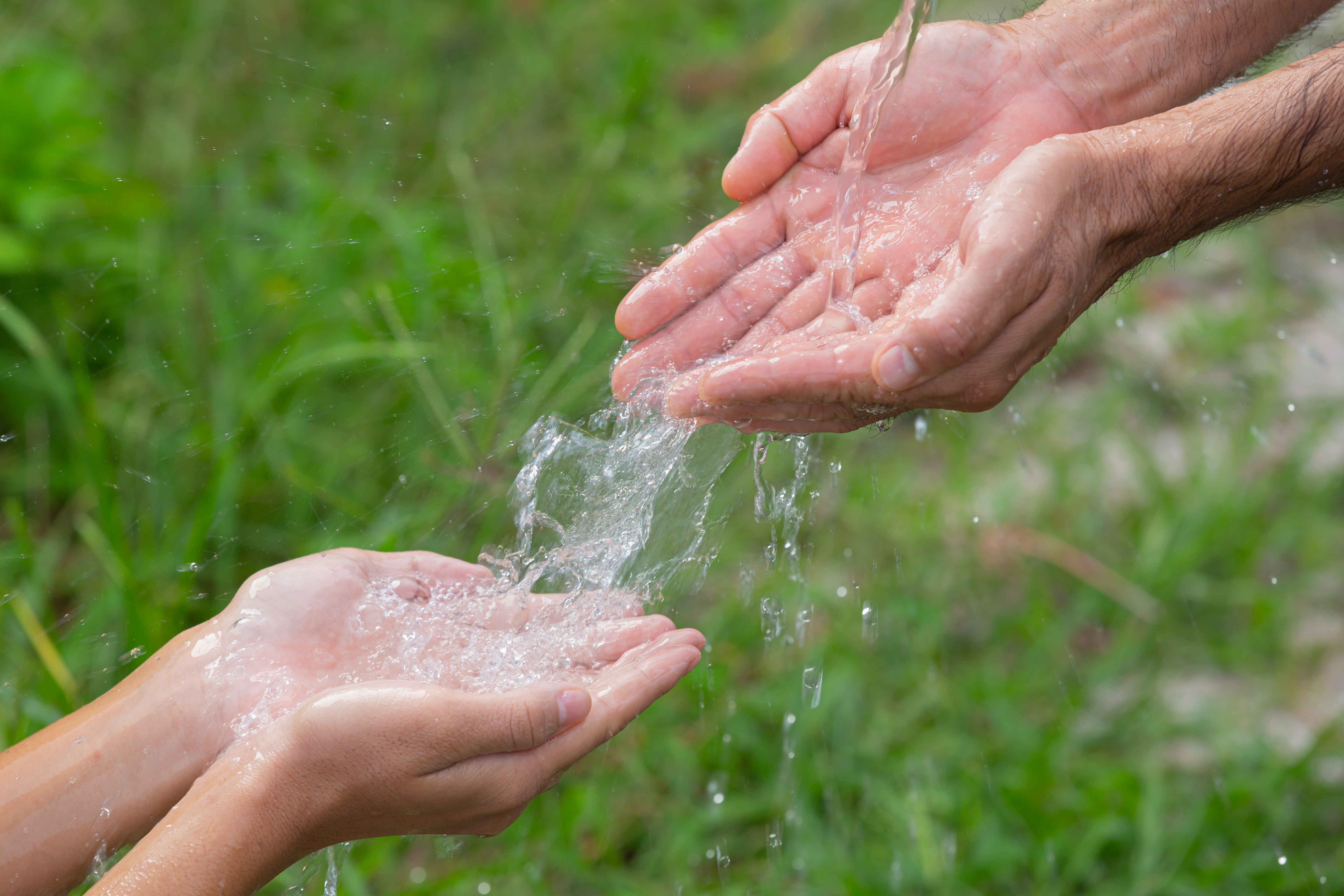 Manos compartiendo una fuente de agua