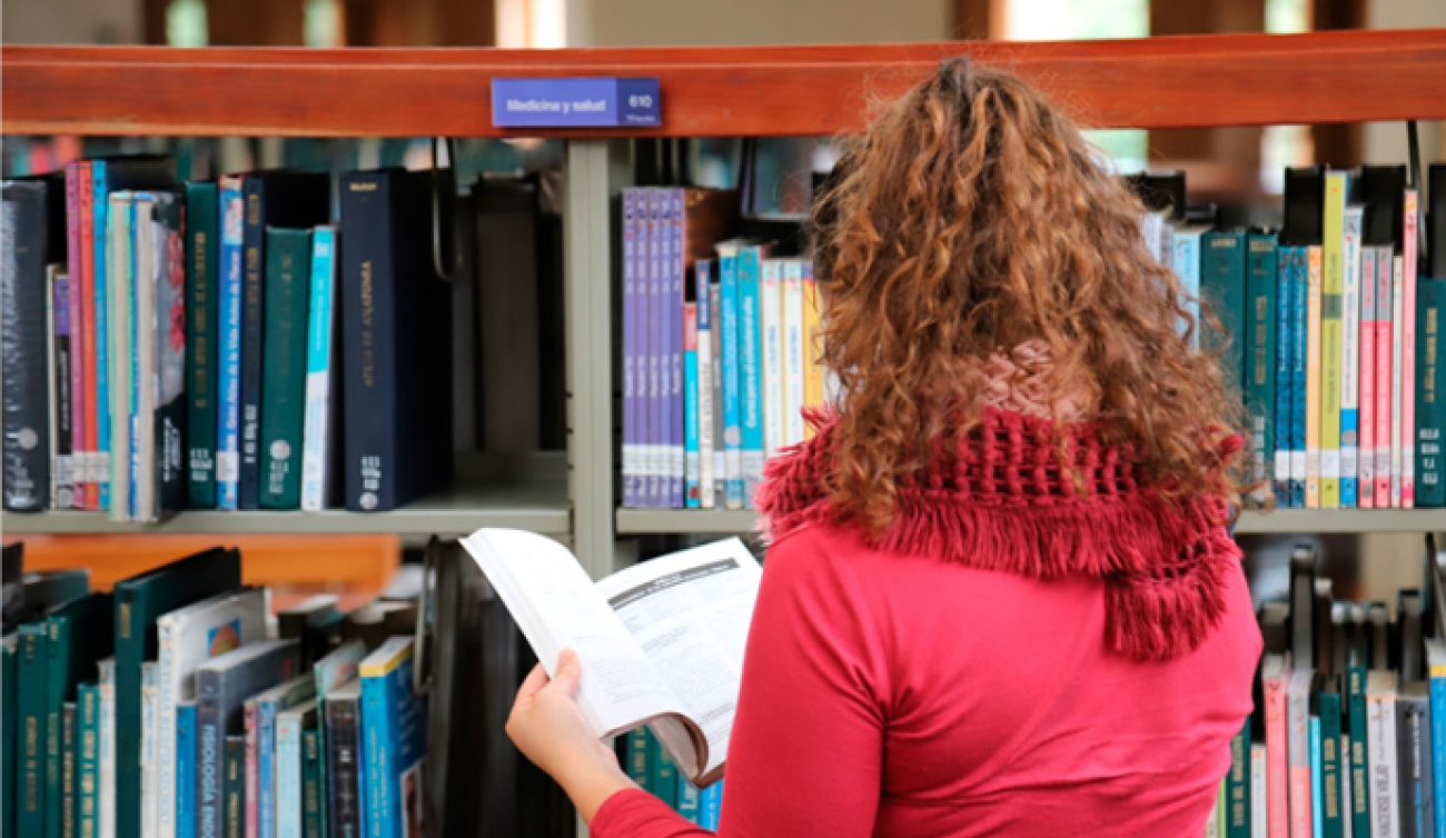 mujer leyendo en una biblioteca