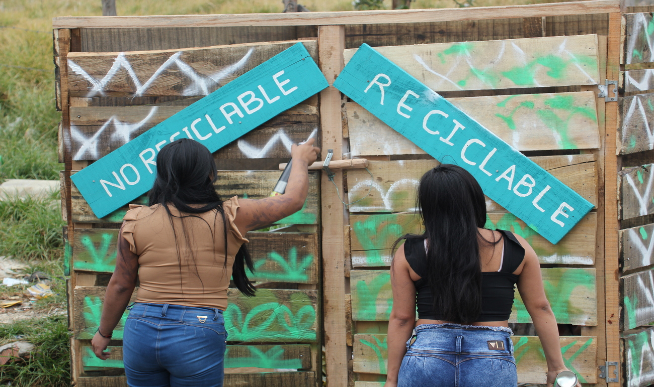 Dos mujeres mirando un letreoro que dice Reciclaje