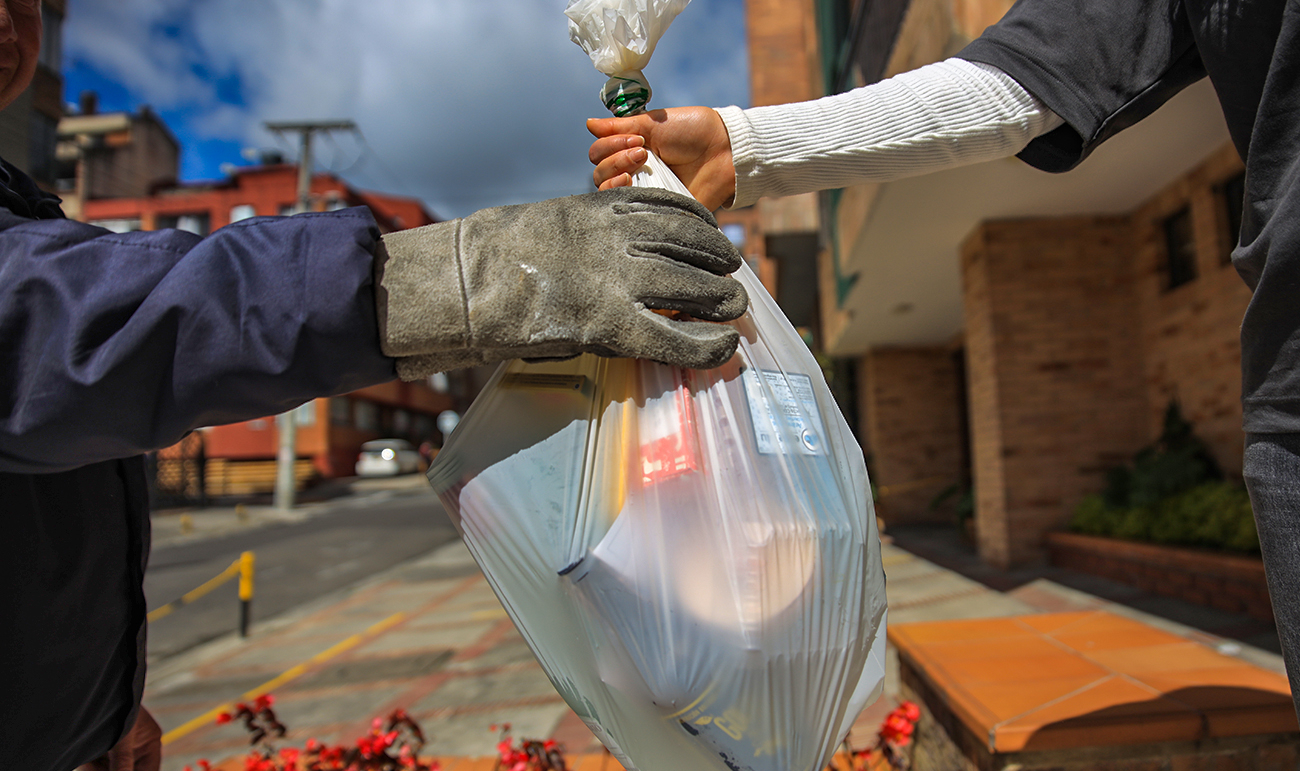 Personas pasando una bolsa de basura