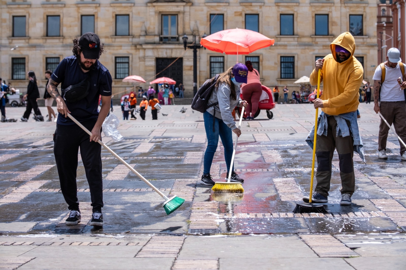 Personas barriendo la Plaza de Bolívar