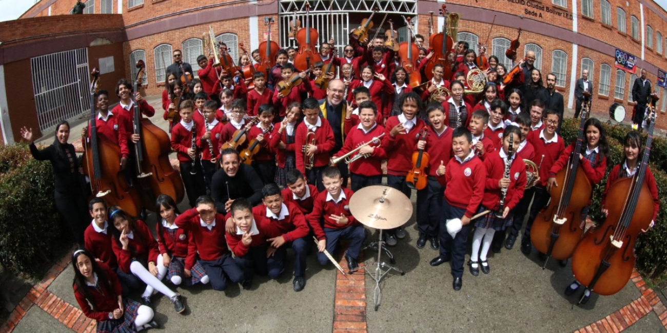 Foto de la Filarmónica en un colegio de Bogotá y sus alumnos