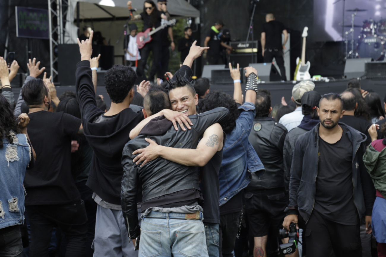 Personas en concierto de rock, abrazándose