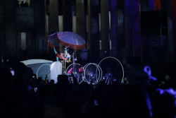 Bicicleta gigante con artistas danzando