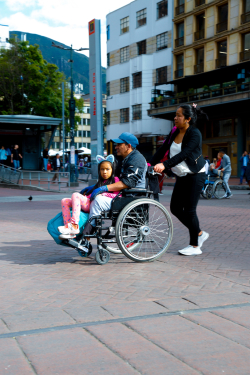 persona en silla de ruedas con niña las piernas