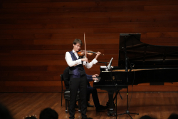 Música interpretando el violín en un teatro