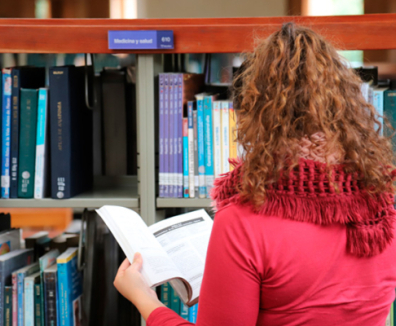 mujer leyendo en una biblioteca