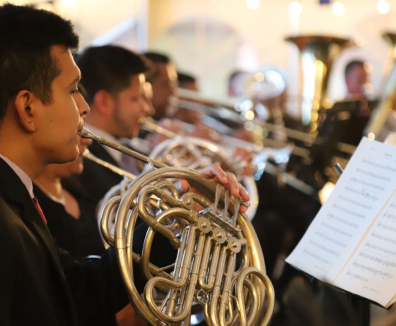 hombre tocando un instrumento musical mientras lee una partitura