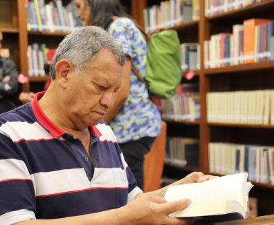 persona mayor leyendo en una biblioteca