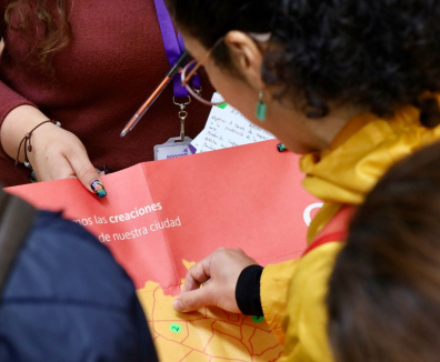 Mujer poniendo un sticker en mapa de Bogotá