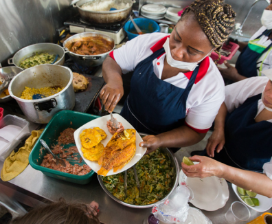 Mujer en una cocina sirviendo un plato de comida