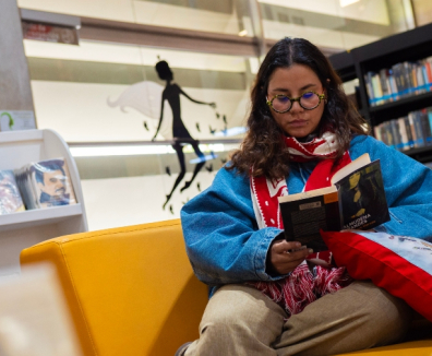 mujer leyendo en una biblioteca