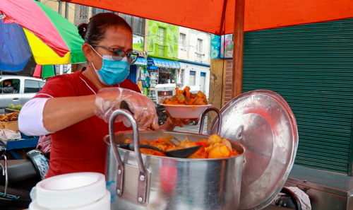 Mujer siviendo comida | Bogotá Comensal
