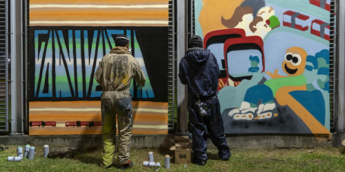 dos jovenes pintando grafiti en Bogotá