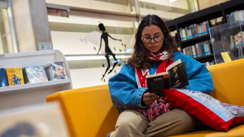mujer leyendo en una biblioteca