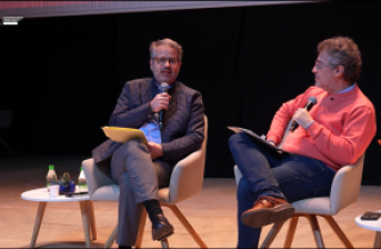  José Antonio Torre y Jorge Melguizo conversando en un auditorio