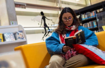 mujer leyendo en una biblioteca