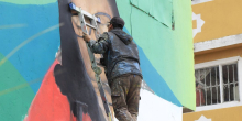 Artista visual pintando un mural en Ciudad Bolívar