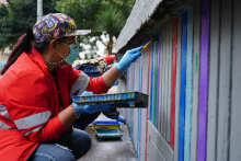 Mujer pintando una calle de Bogotá en jornada del Centro Vive